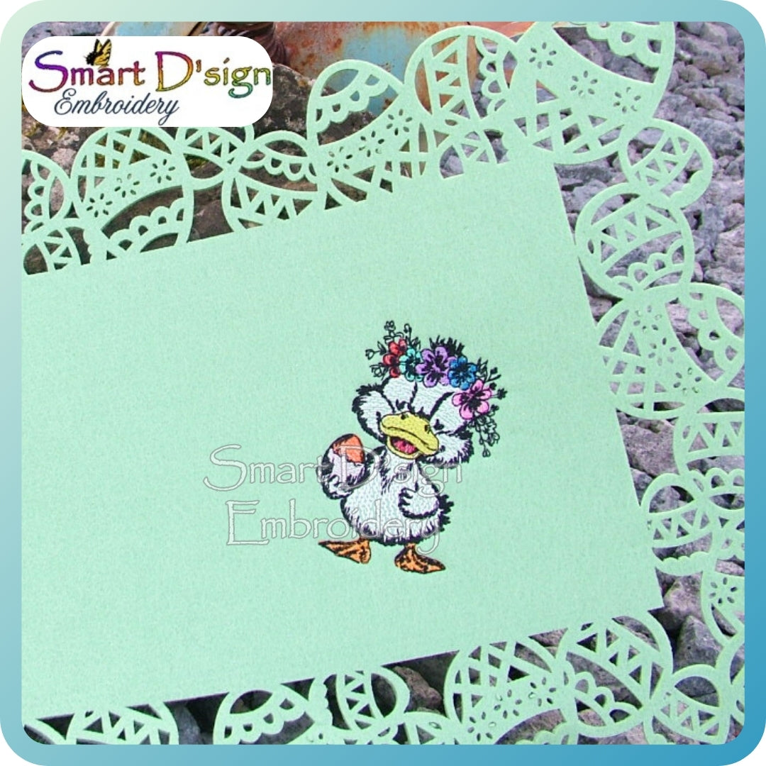 Embroidered design of a duck with flowers on a green card with decorative lace border, branded 'Smart D'sign Embroidery'.